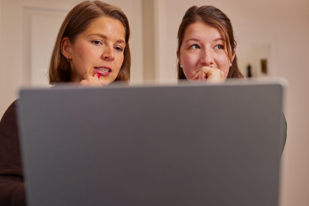 Online Marketing bei ooniyo | Rebecca und Wiebke stehen am Laptop und besprechen eine neue Online Marketing Strategie